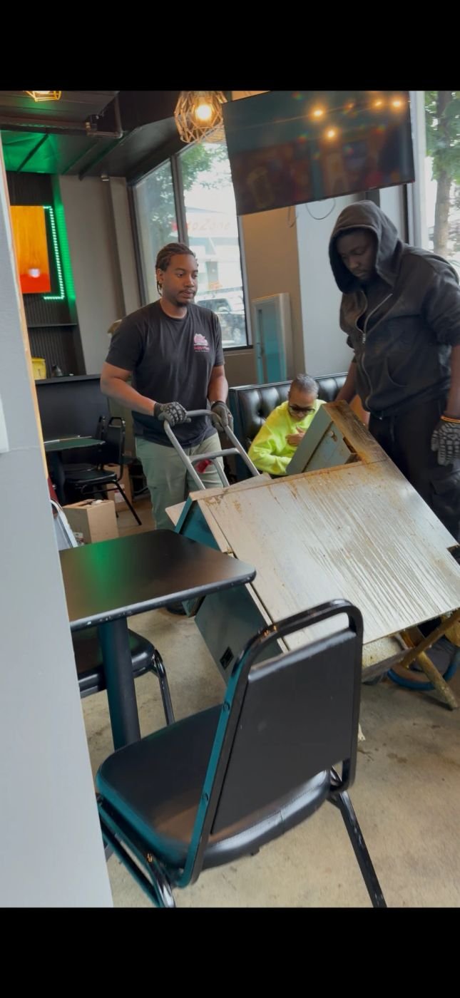 Crew moving heavy furniture out of a commercial space