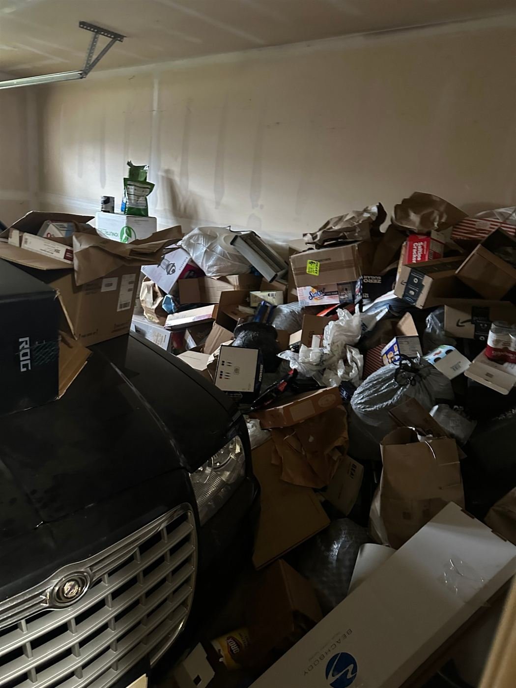 Boxes crowding out the car in a Kent garage before cleanout