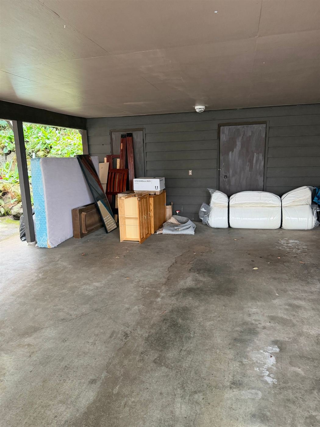 Furniture staged in a carport for junk removal in Kent